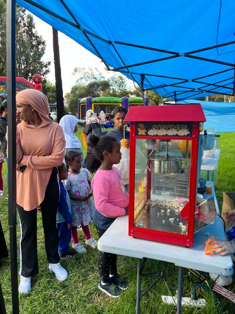 Children waiting at the popcorn stand at an SWDA family fun day