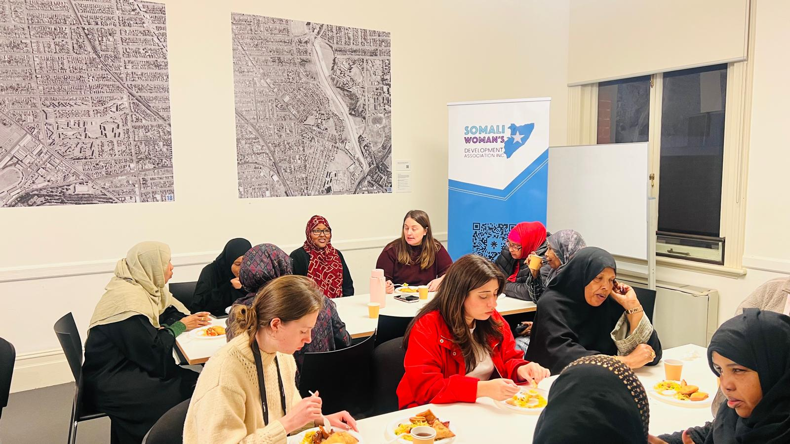 Women attending an SWDA Employment Brokers workshop, sharing a meal beside SWDA banners