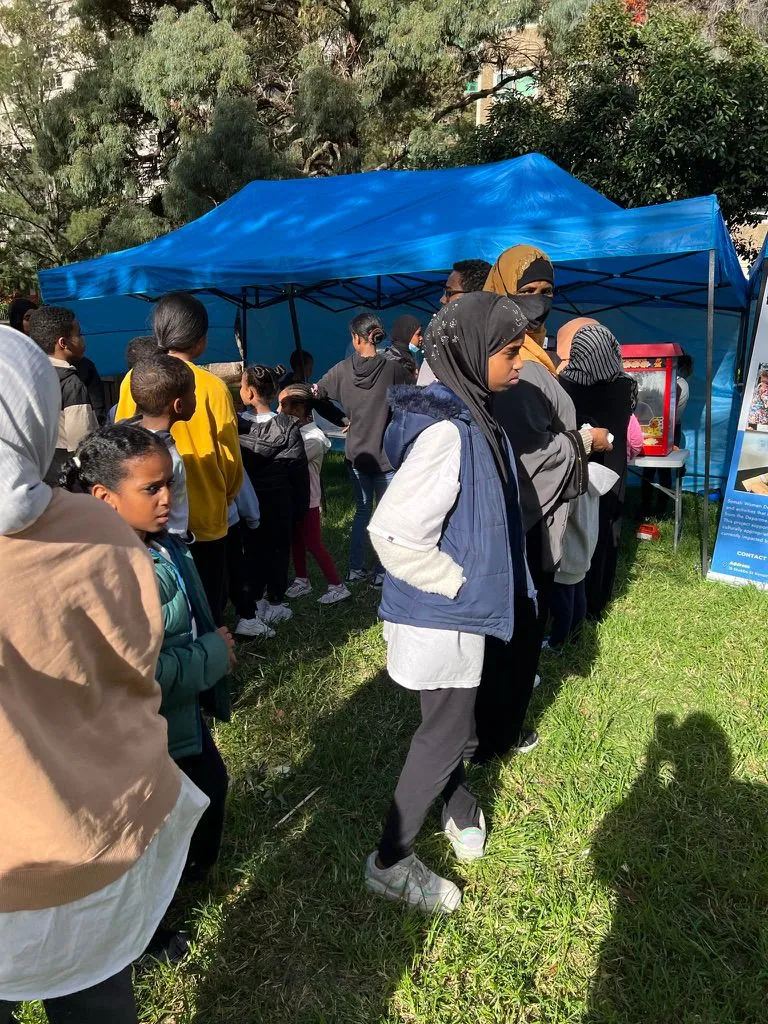 Children and young people lining up for activities at an SWDA community event