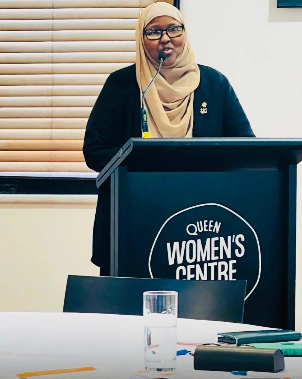 SWDA representative speaking at a podium during a community forum