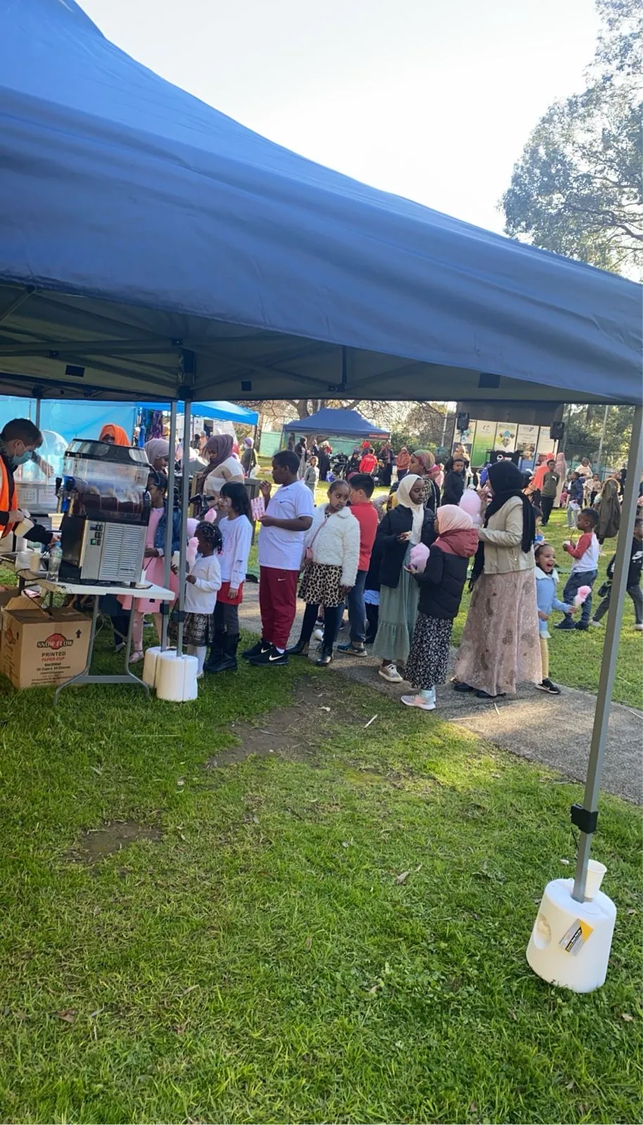 Children queuing for drinks and fairy floss at an SWDA family fun day