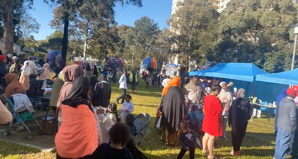 Large crowd of families enjoying rides and stalls at the Multicultural Eid Festival