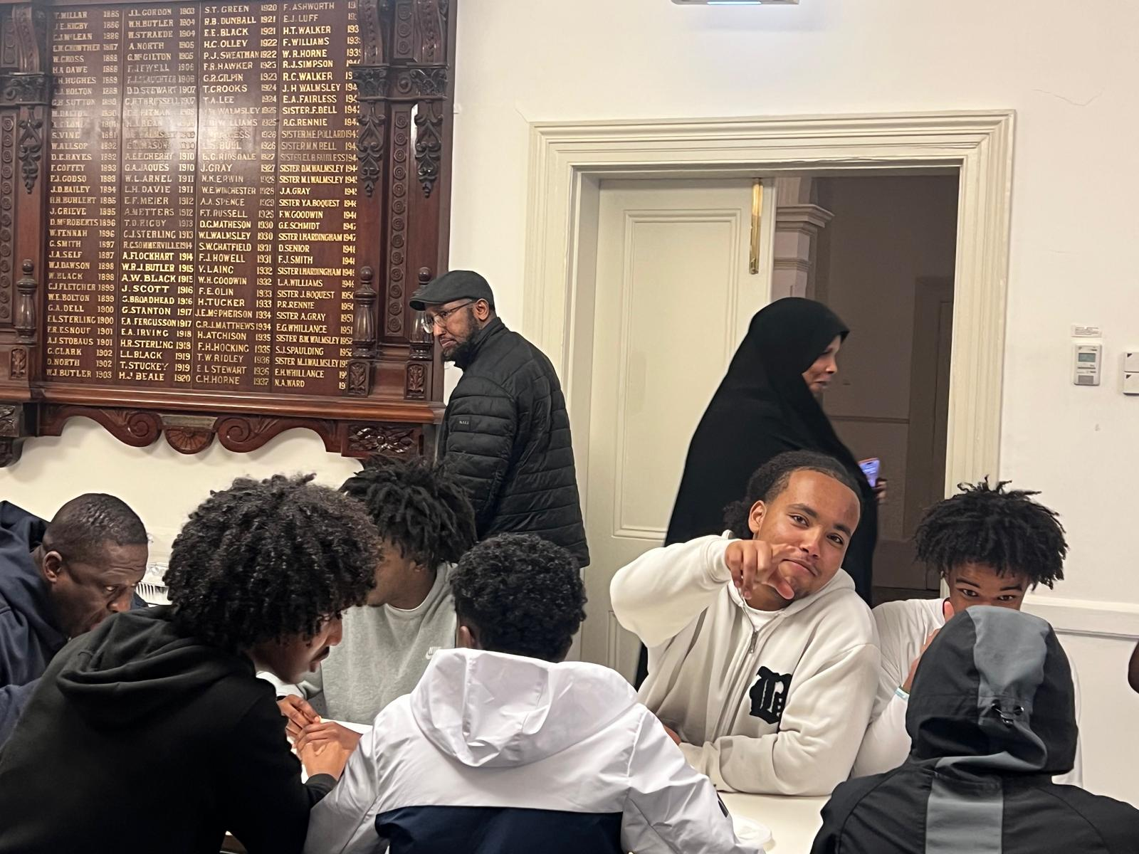 Young people gathered around a table at an SWDA community event