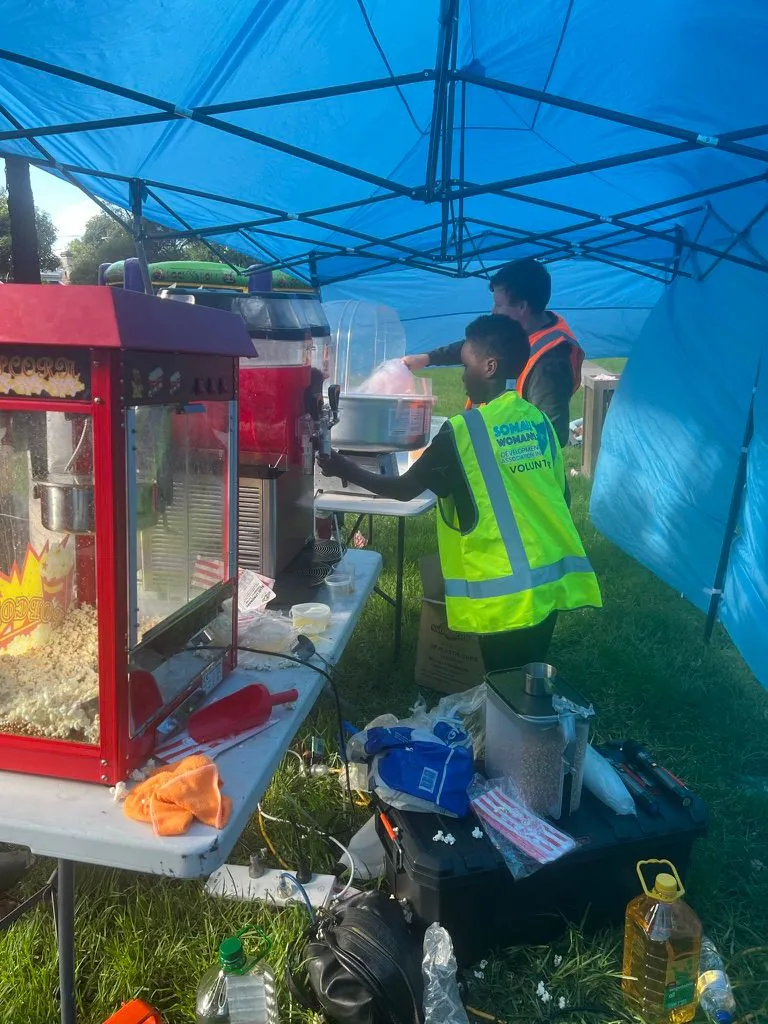 SWDA youth volunteers running the popcorn and drinks stall at a community festival
