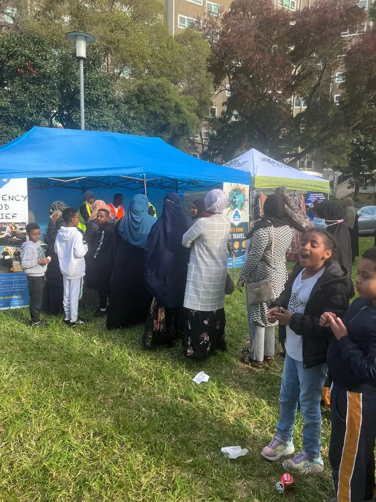 Families gathering at the SWDA Emergency Food Relief marquee in the park