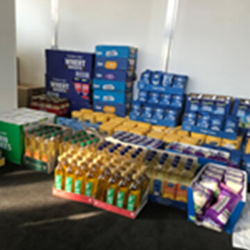 Pallets of donated pantry staples and drinks ready for distribution