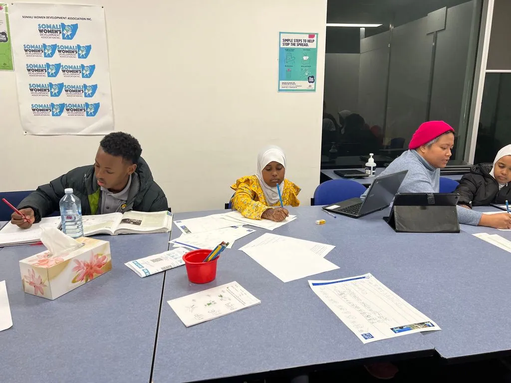 Homework Club students working on their studies with tutors at an evening session