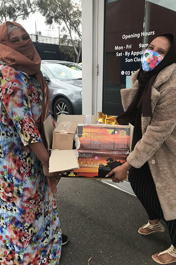 SWDA volunteer handing over a food relief parcel at the Kensington office