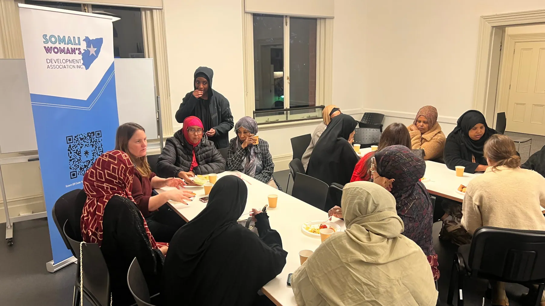 Wide view of an SWDA community information evening with shared food and discussion