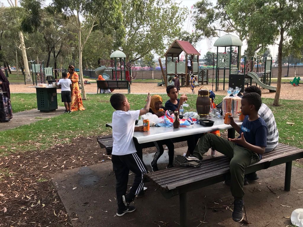 Homework Club families and children enjoying a school holiday picnic in the park