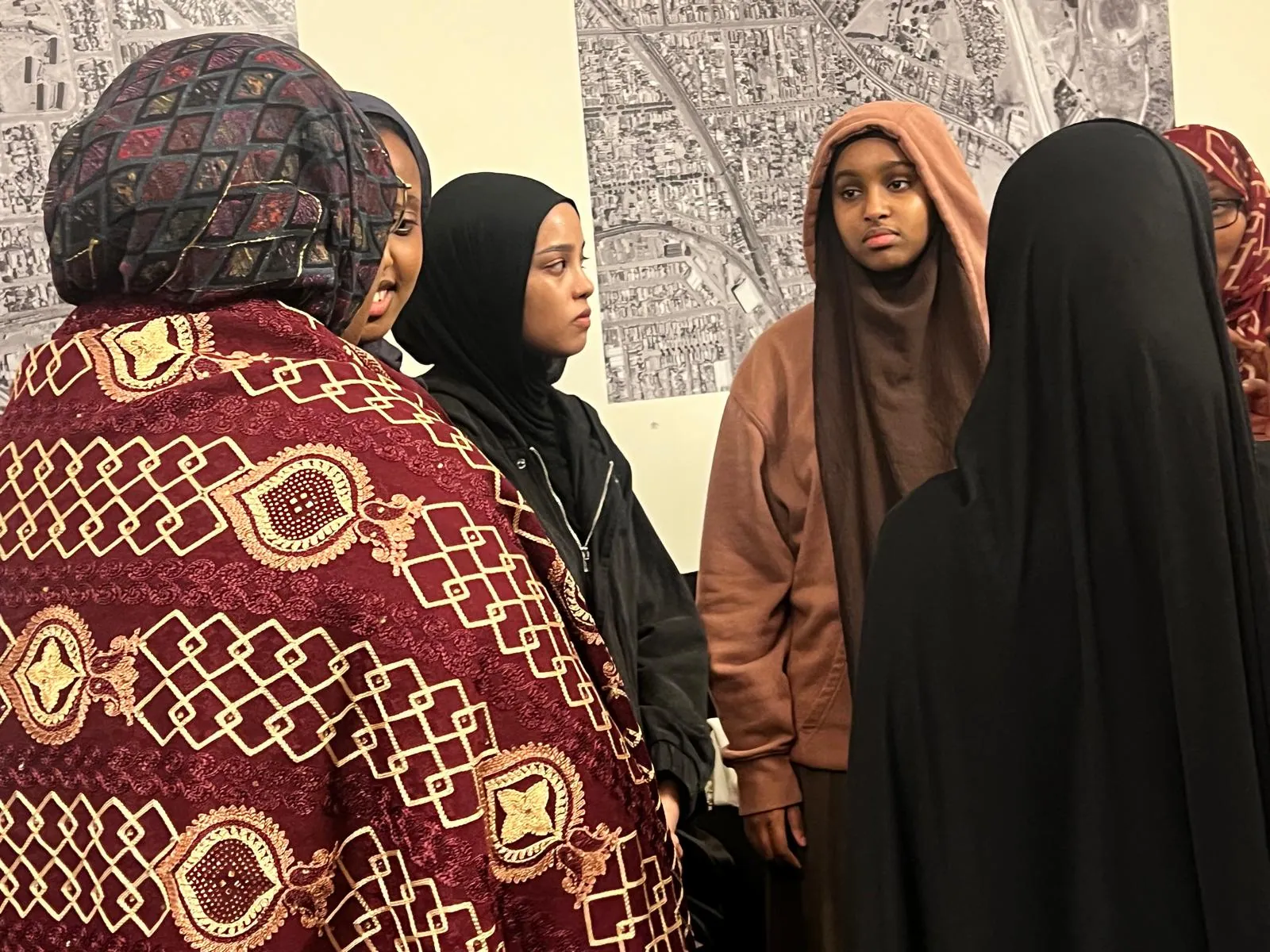 Young women and community members in conversation at an SWDA event